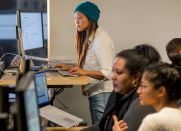 A female developer works at a standing desk