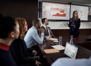 A woman presents Salesforce reports to a conference room